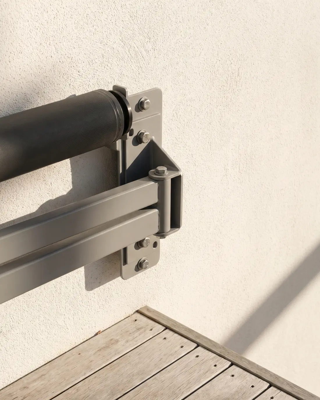 Close detail of a folding arm awning bracket fixed to a wall