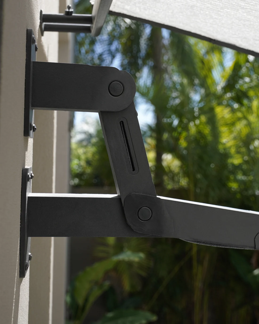 The folding arm and wall bracket of a retractable awning