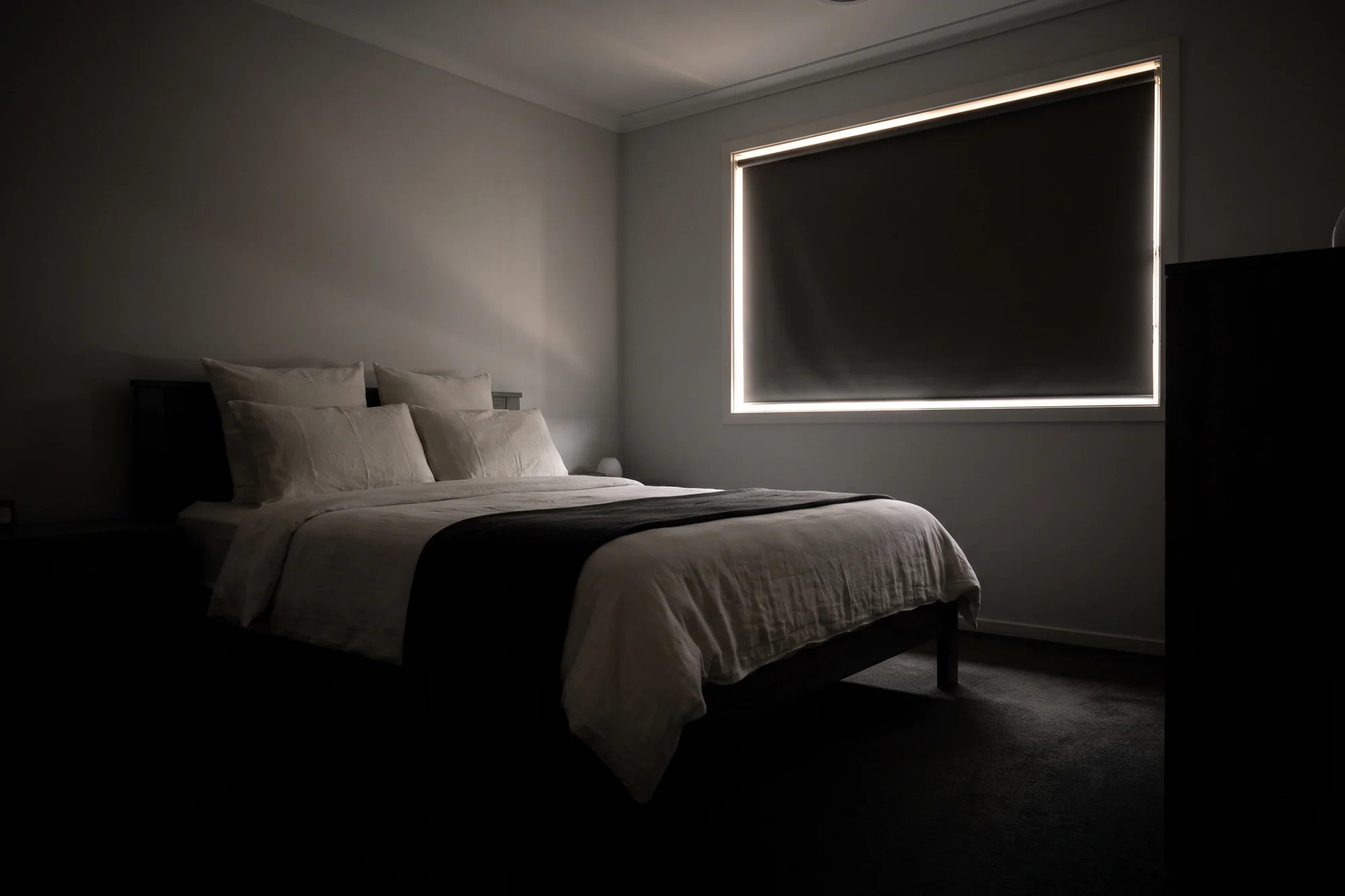 Gold Coast bedroom darkened by blockout blinds at the window