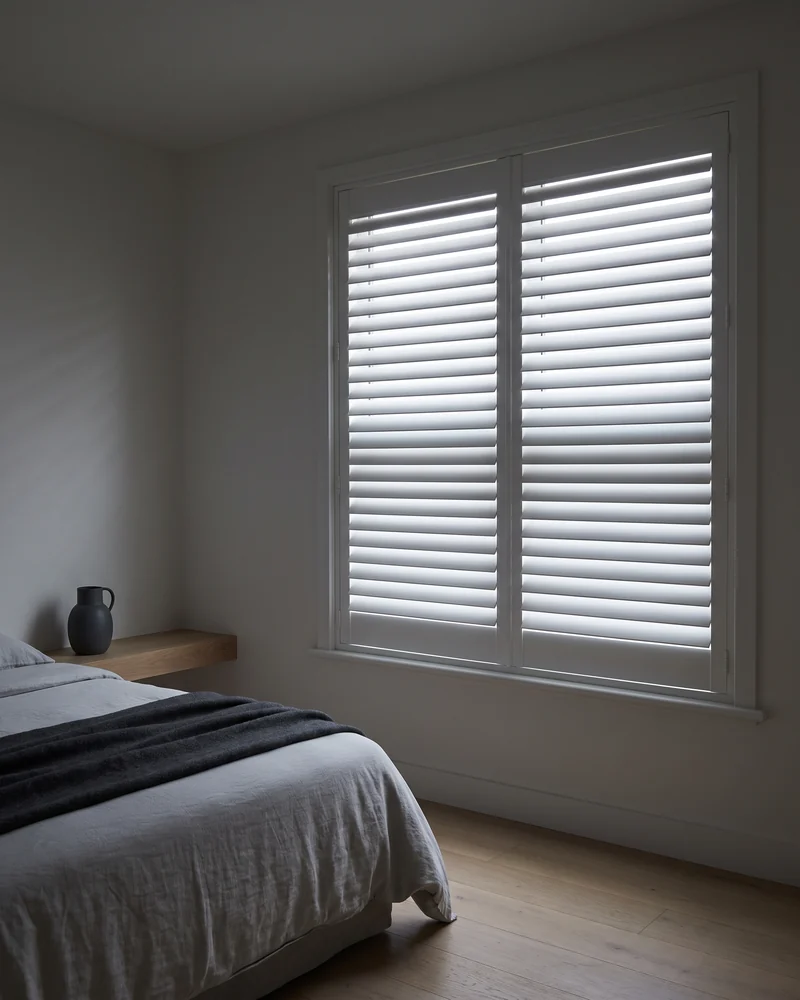 Bedroom shutters with the louvres closed, daylight showing between the blades