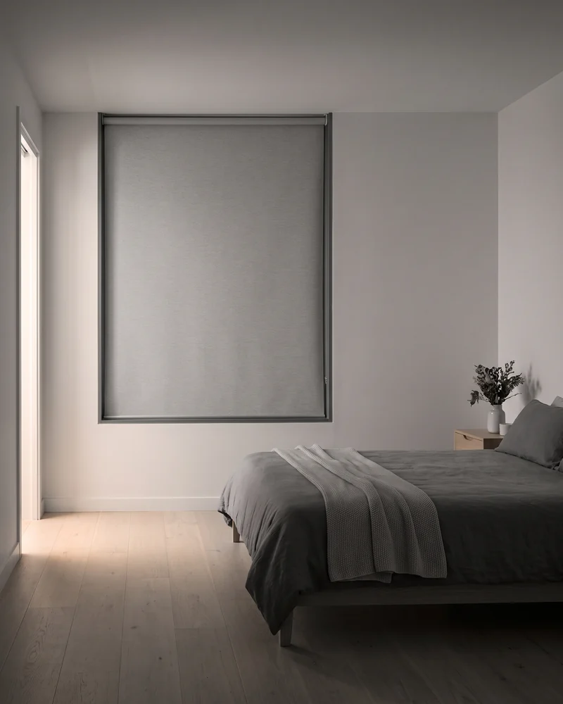 Blockout blind with side tracks in a darkened bedroom
