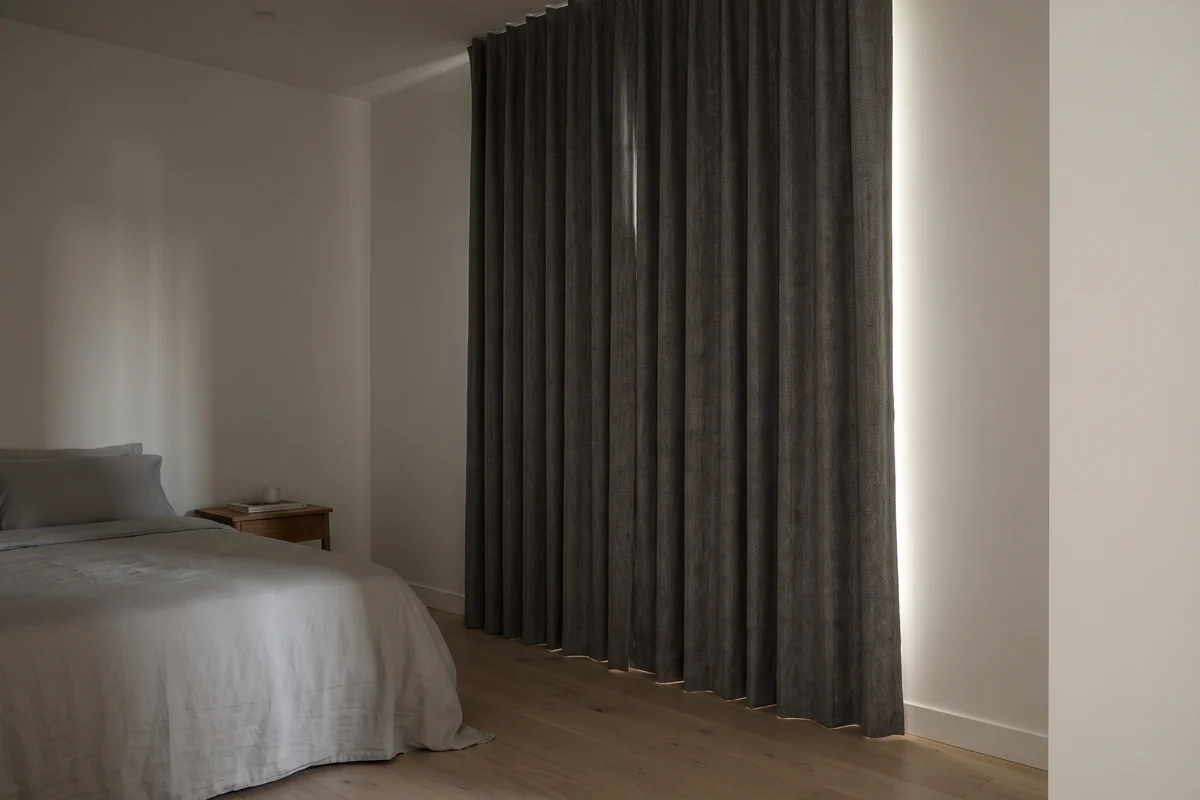 Bedroom with floor-length blockout curtains drawn closed against morning light