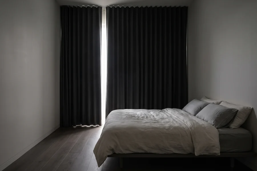 Bedroom with heavy blockout curtains drawn across the window
