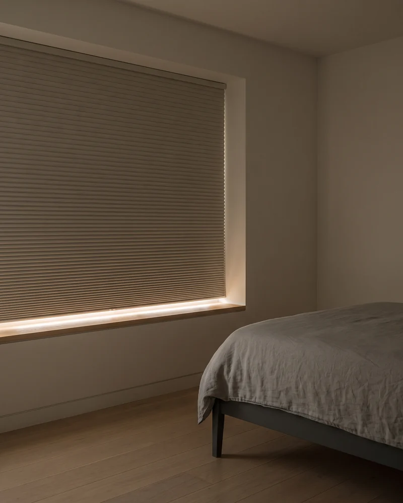 A blockout honeycomb blind lowered in a bedroom