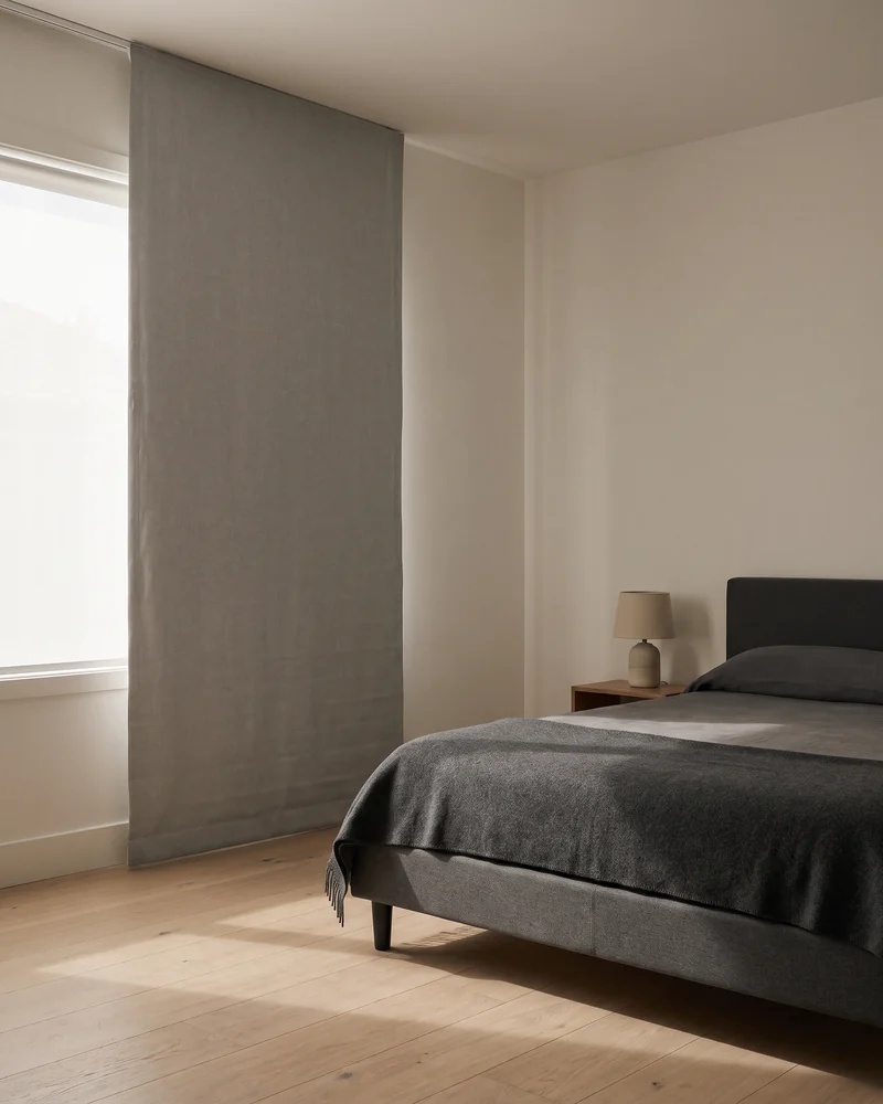 A blockout-lined Roman blind lowered in a bedroom