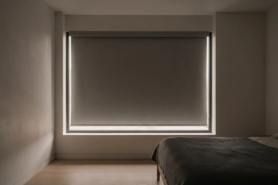 A blockout roller blind lowered in side channels beneath a cassette headbox