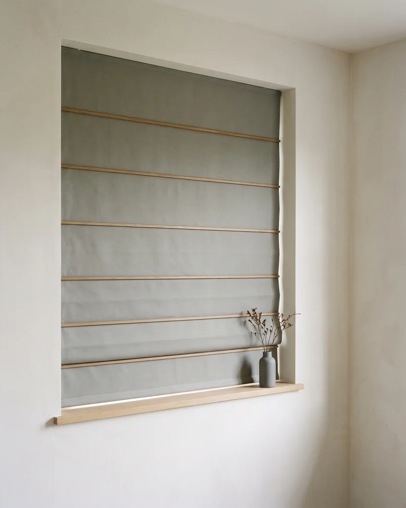 Blockout roman blind lowered flat over a window in even horizontal folds