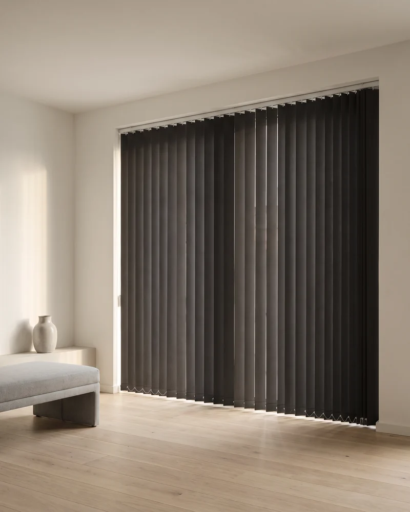 Blockout vertical blinds with the vanes rotated fully closed across a wide window