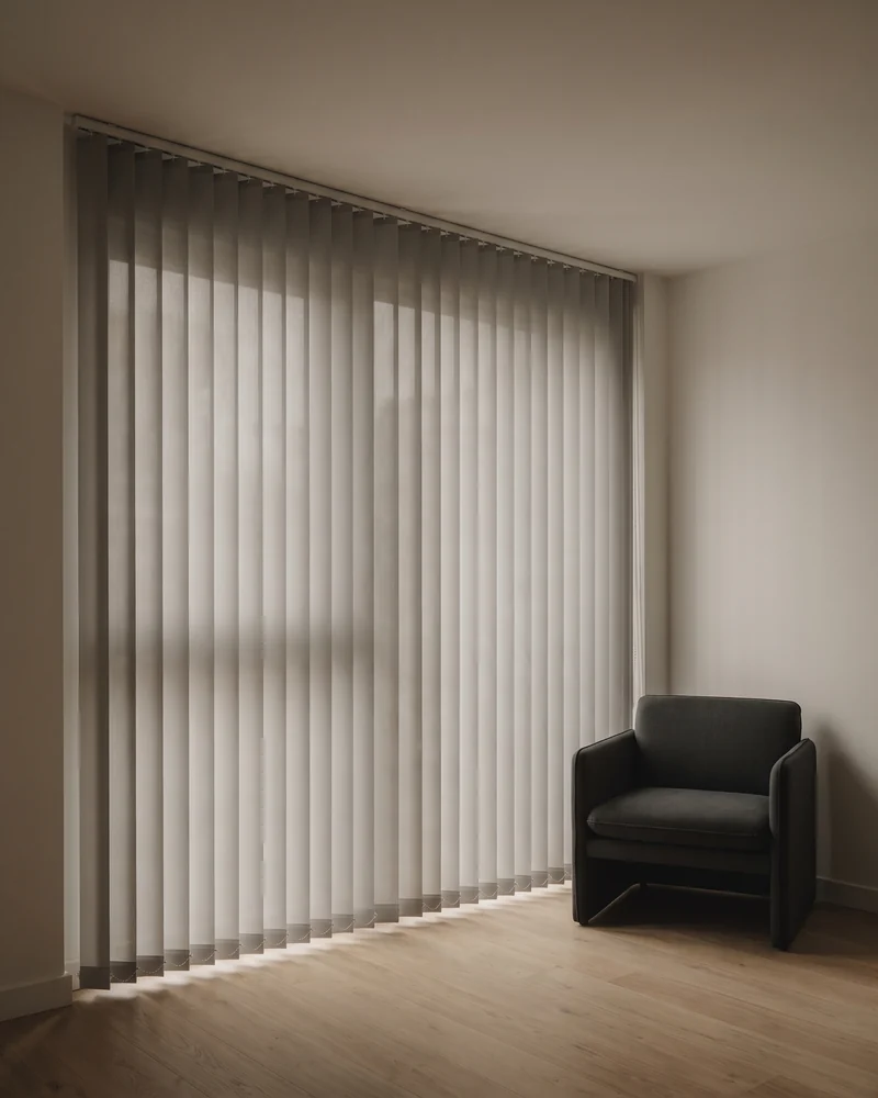 Blockout vertical blinds across a wide living room window