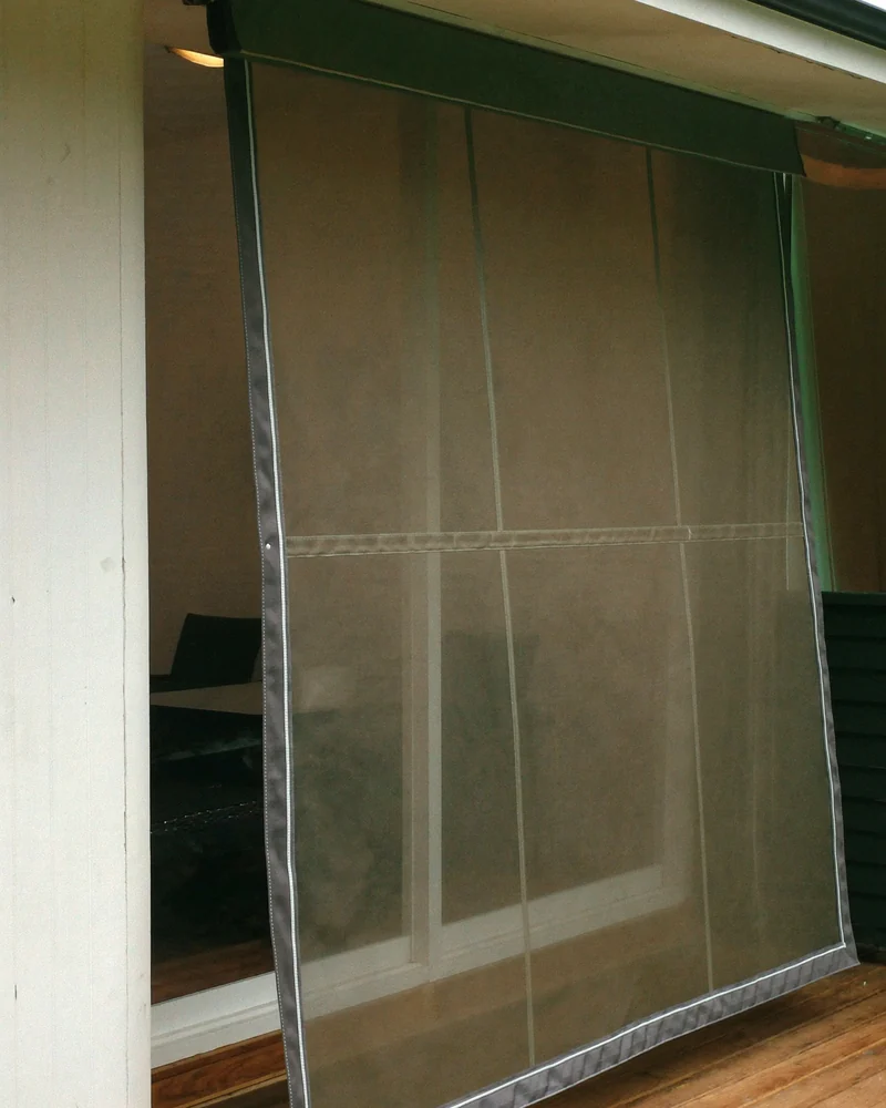 A caf&eacute; blind with clear PVC panels lowered across a balcony opening