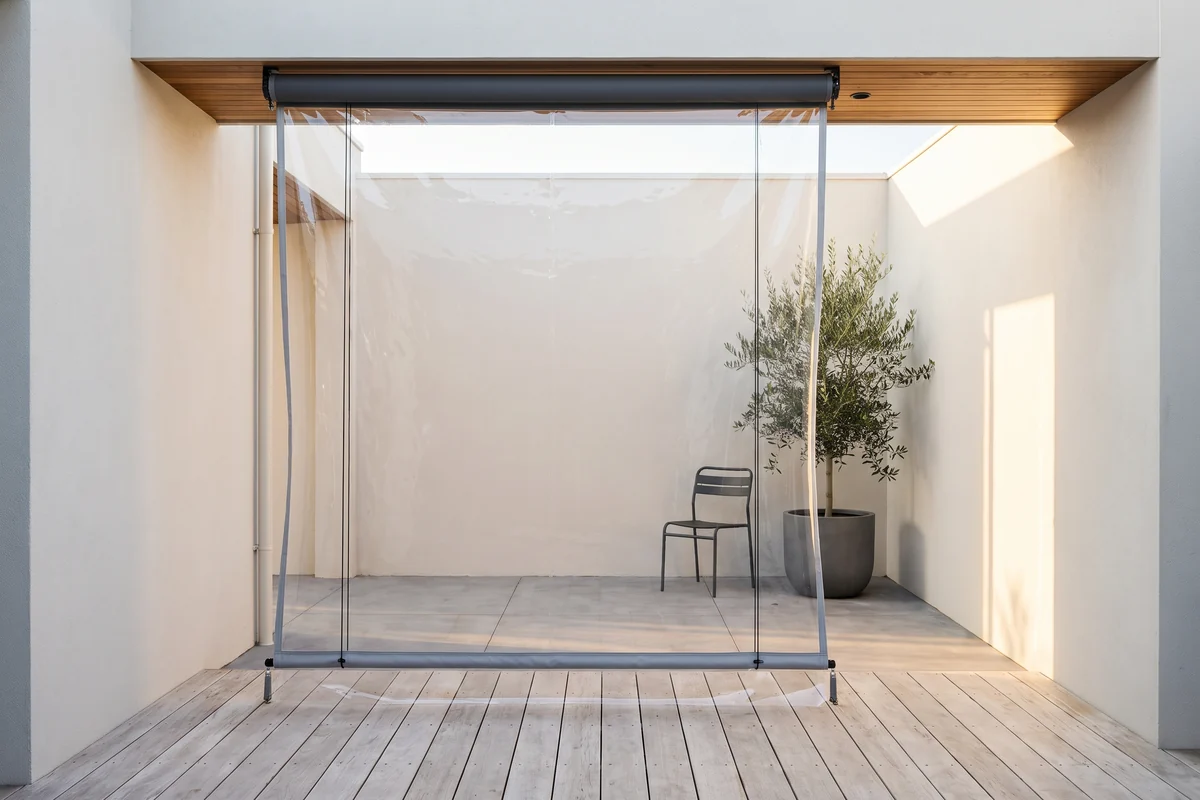 An outdoor blind lowered across an alfresco opening