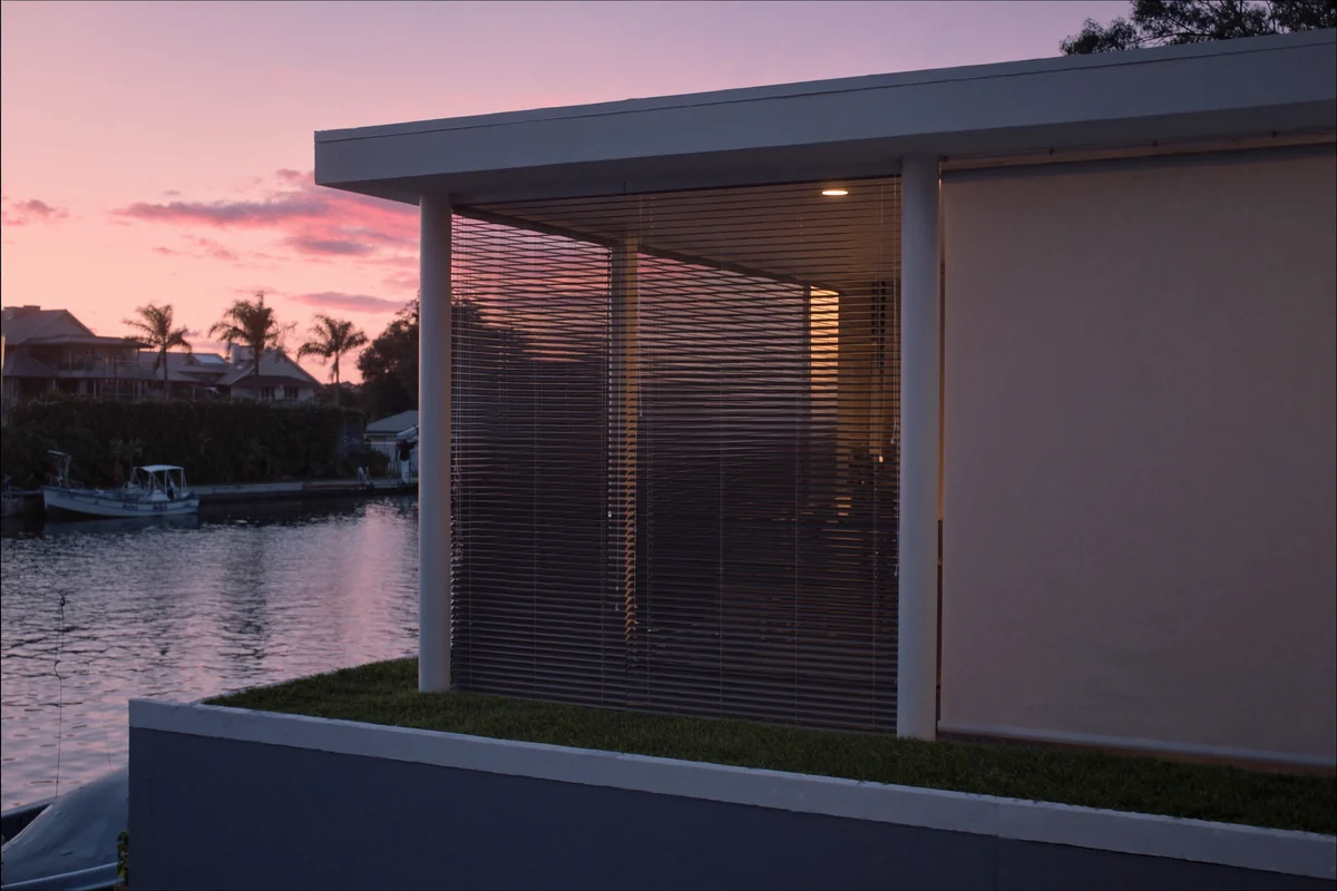 A waterfront home with a covered outdoor area at dusk