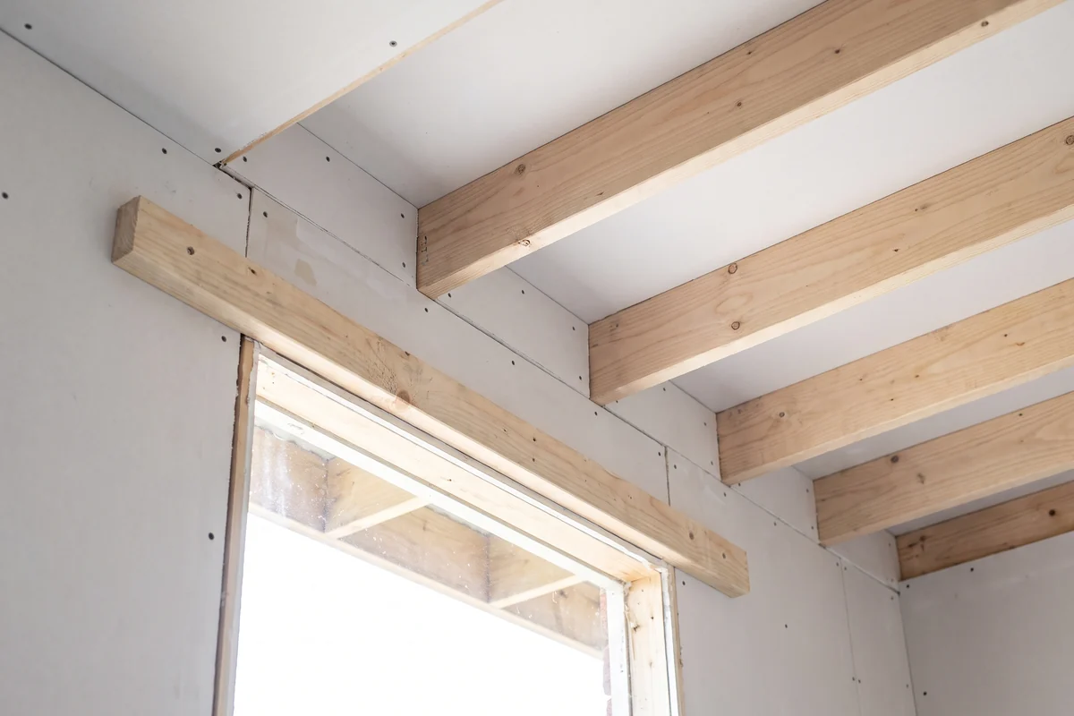 Timber batten fixed above a window opening between ceiling joists