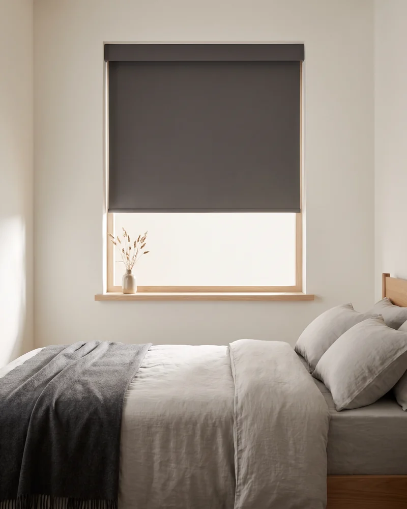 Cordless blockout roller blind over a bedroom window with no chain at either side