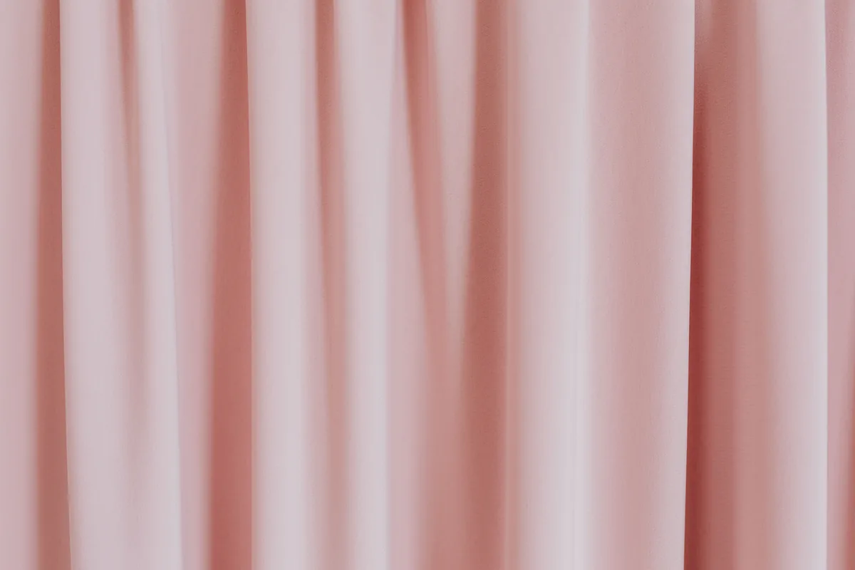 Curtain fabric falling in deep, evenly spaced vertical folds