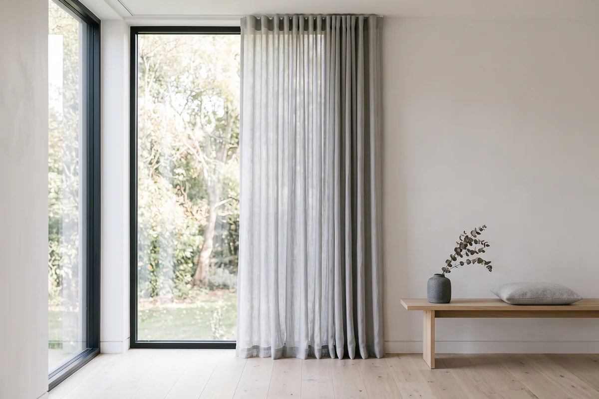 Floor-length curtains hanging beside a tall living-room window