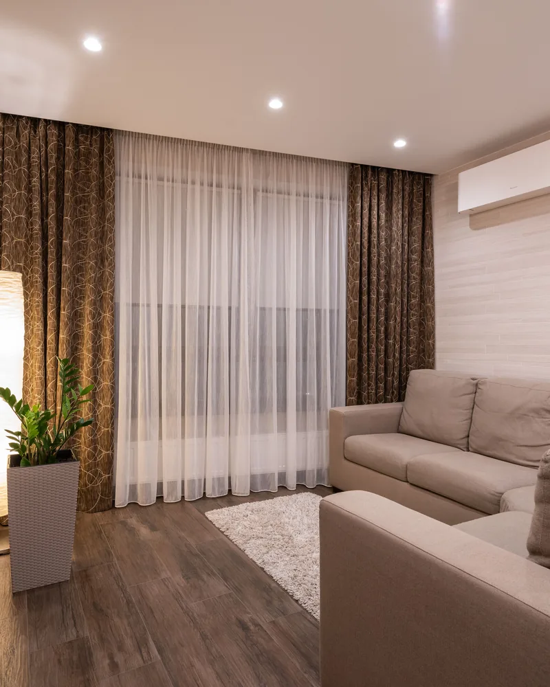 Curtains framing a living room window behind a sofa