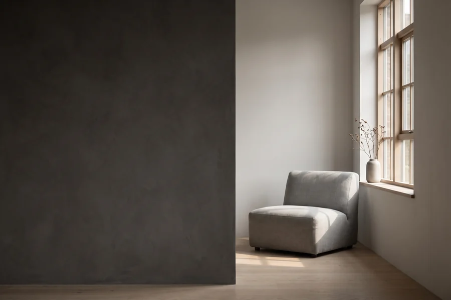 Interior with a dark feature wall and a single armchair by the window
