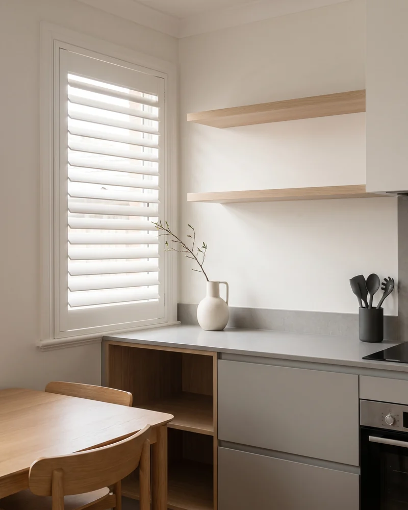 A shuttered window beside a kitchen bench in a dining space