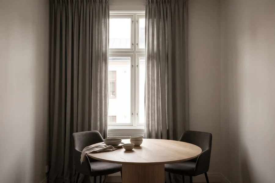 Dining space with curtains beside a window