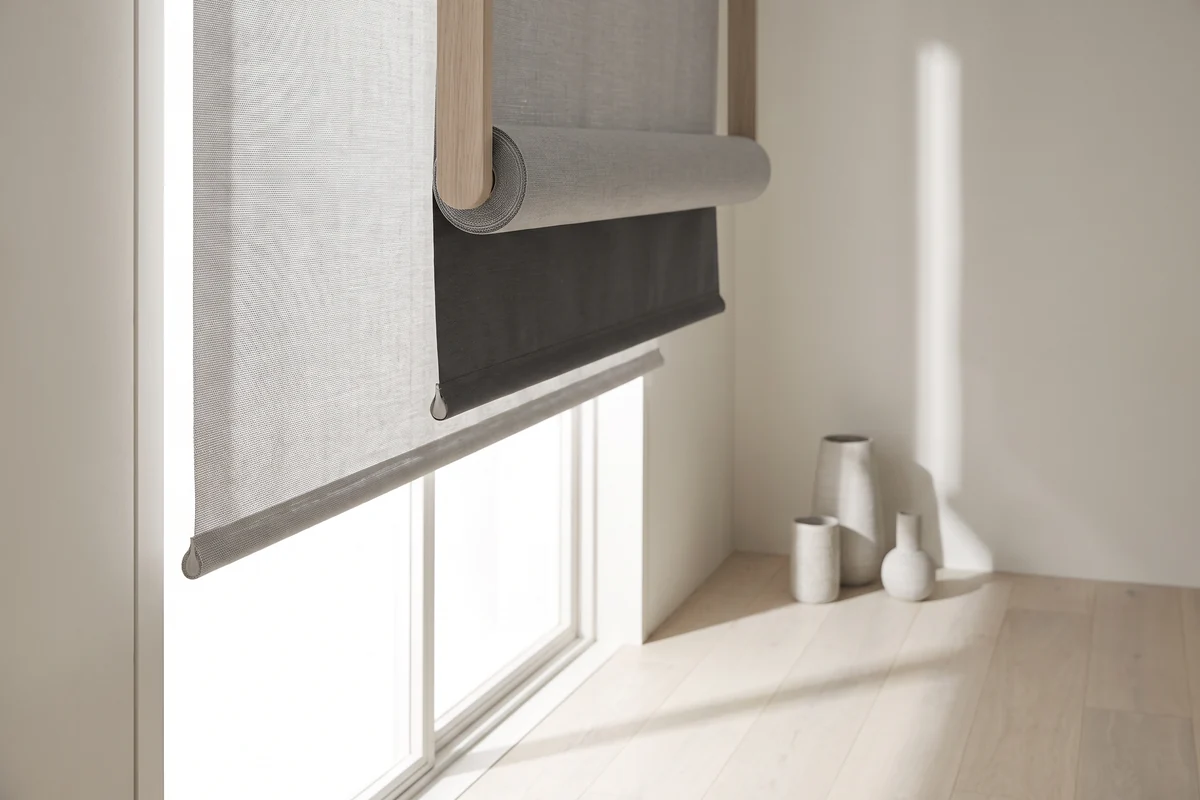 A dual roller blind with a sunscreen and a blockout blind on one bracket