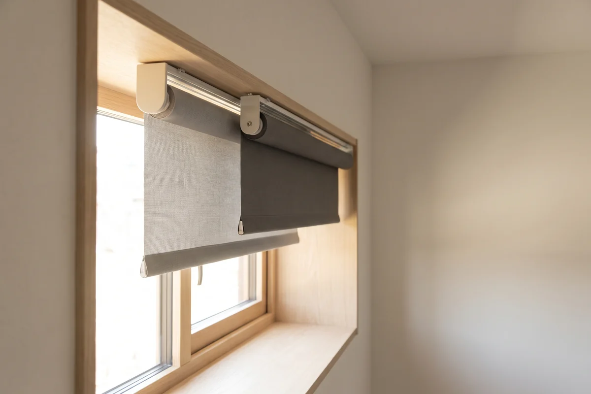 A dual roller blind with a sunscreen layer part lowered in front of a blockout layer