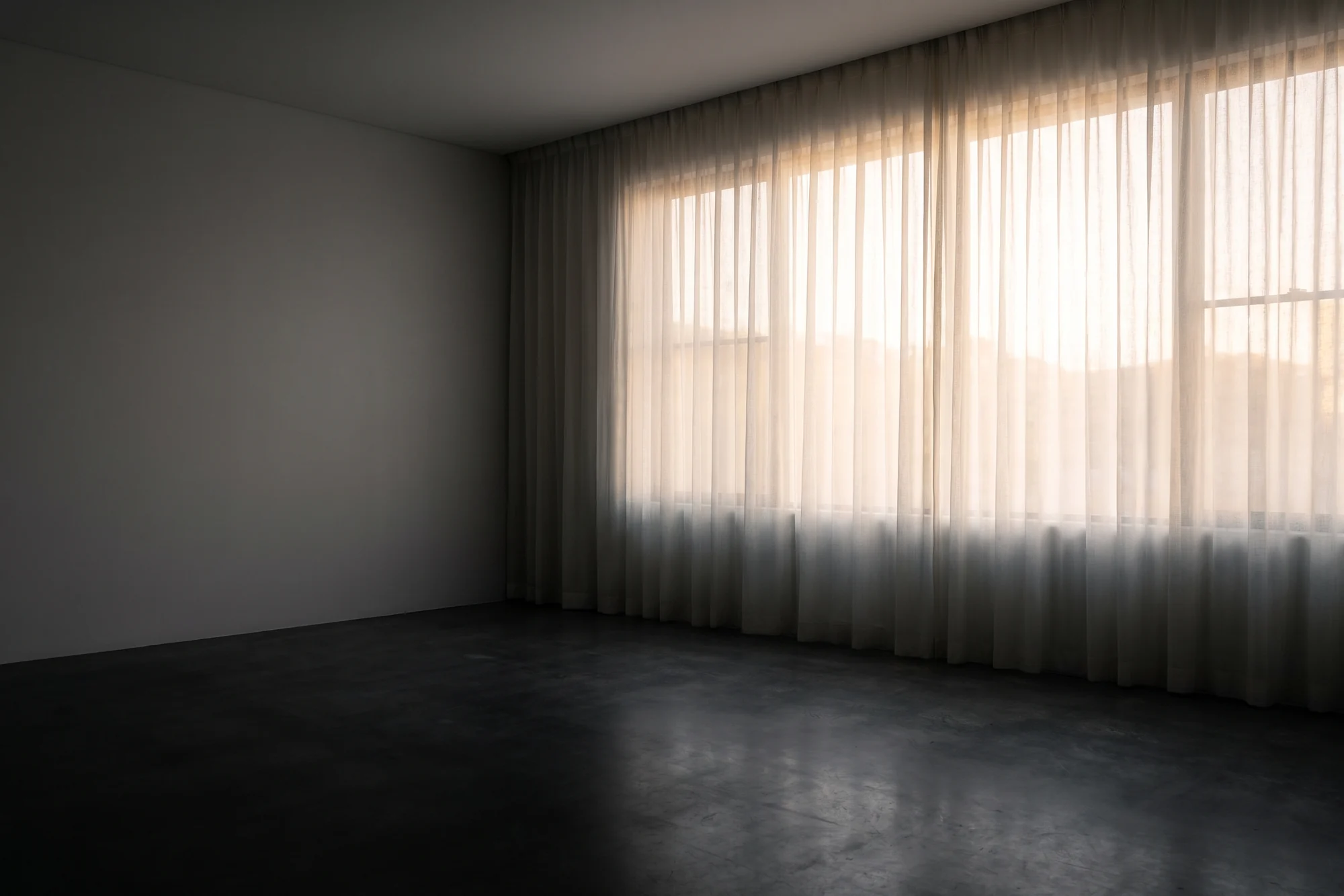 Floor-to-ceiling sheer curtains diffusing daylight across a living room