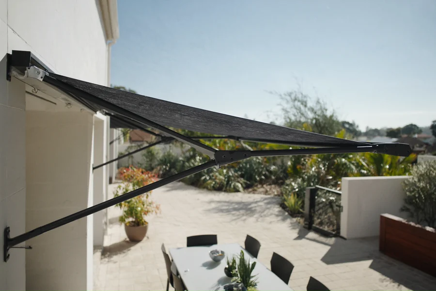 A folding arm awning extended over an outdoor dining setting