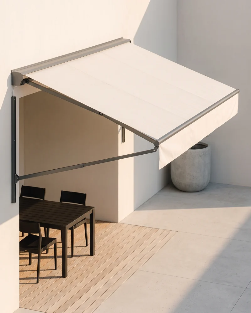 A folding arm awning extended over a paved courtyard