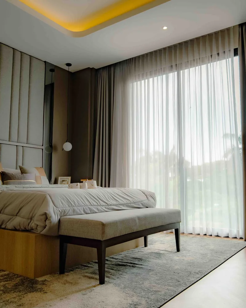 Full-length curtains across a wide sunlit window