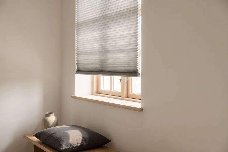 A honeycomb blind partly lowered, its cell structure visible along the edge