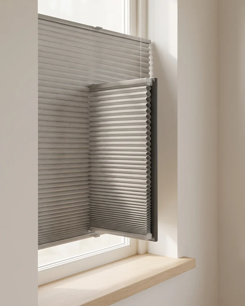 Honeycomb cellular blind in a window reveal with the cell structure visible at the edge