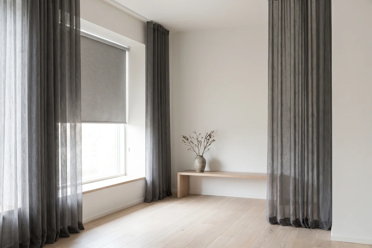 A living room window dressed with both a blind and floor-length curtains
