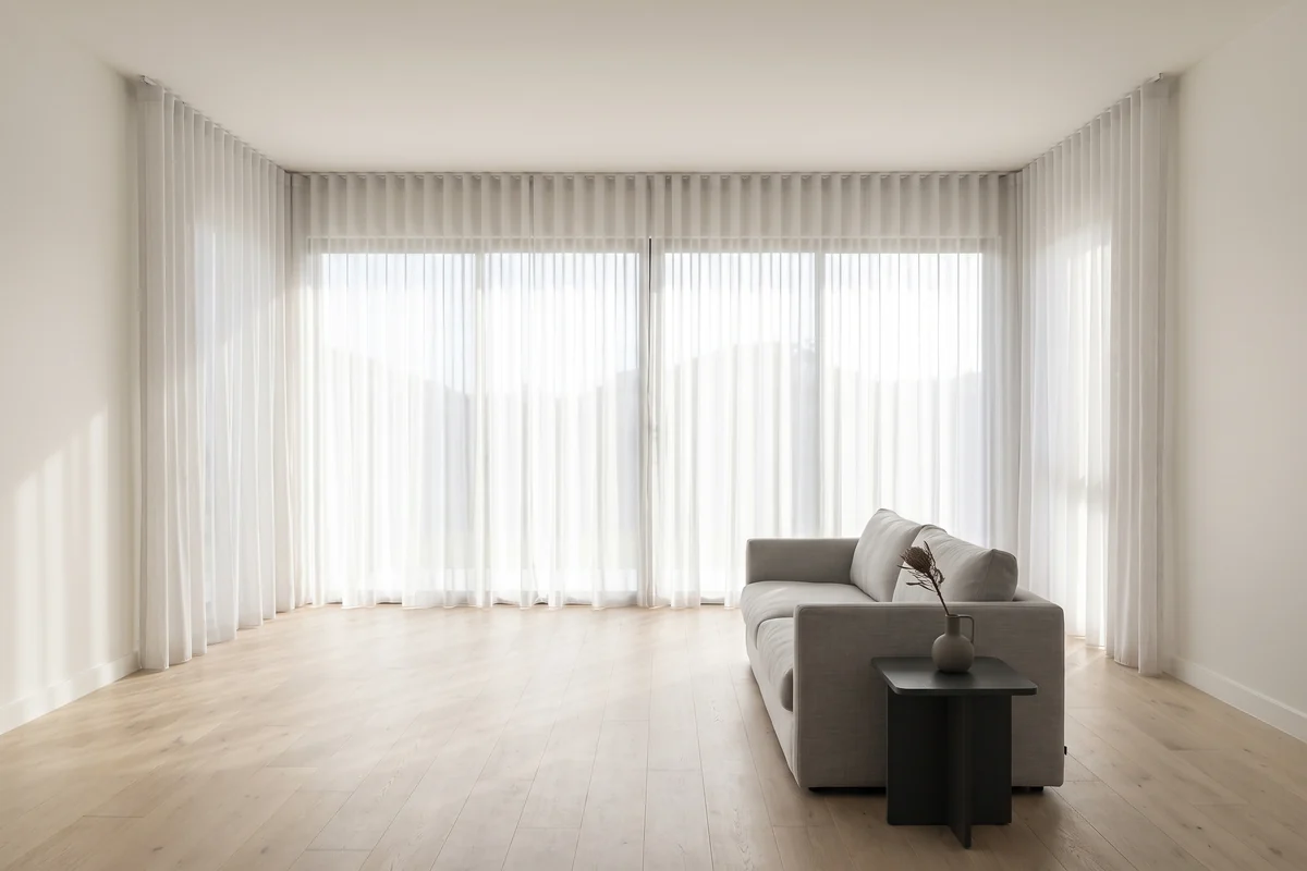 Floor-to-ceiling sheer curtains across a wide living room window