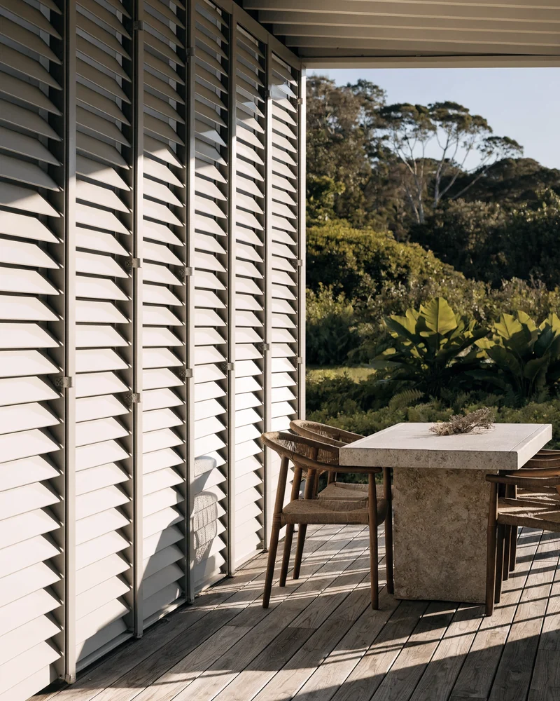 Shutters shading a covered patio at the rear of a house
