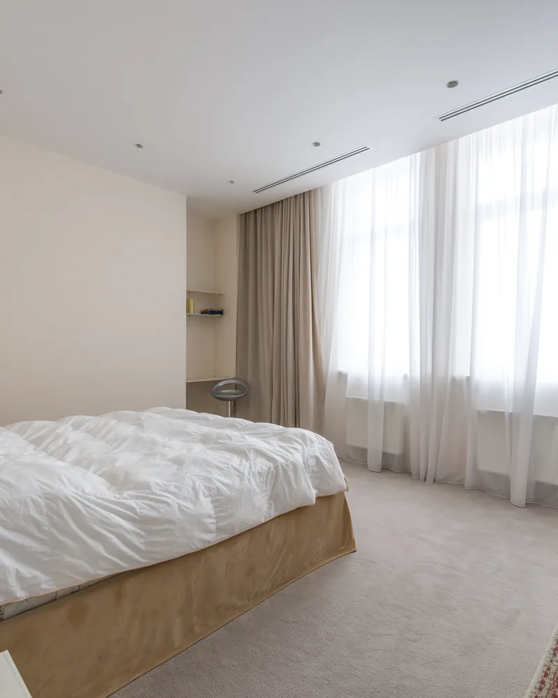A neutral bedroom with daylight at the window