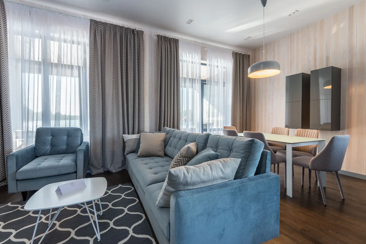 Layered sheers and drapes across several windows in a modern living room