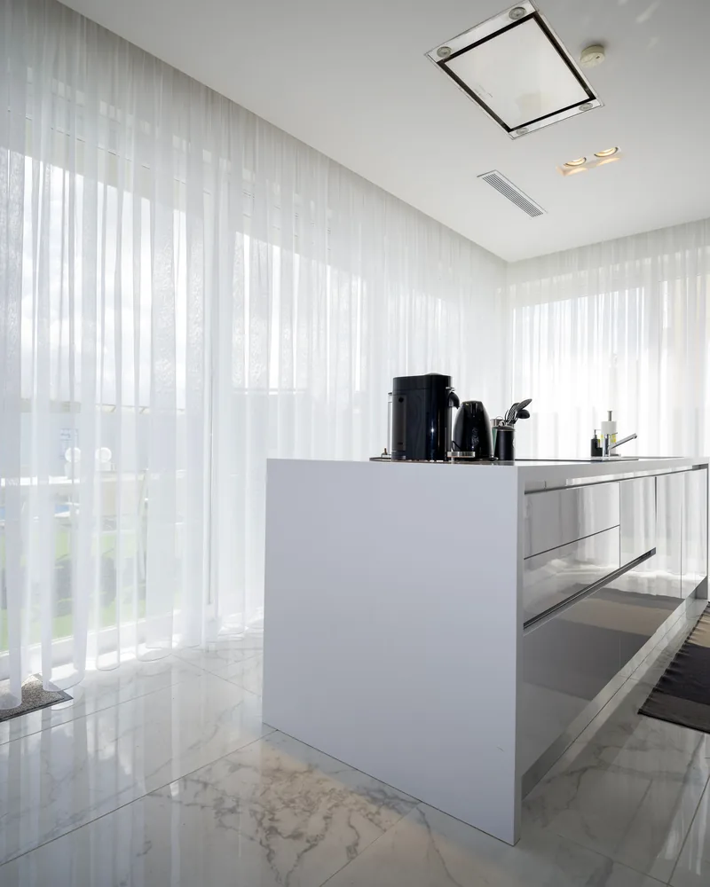Full-length curtains hung to the floor beside a tall window