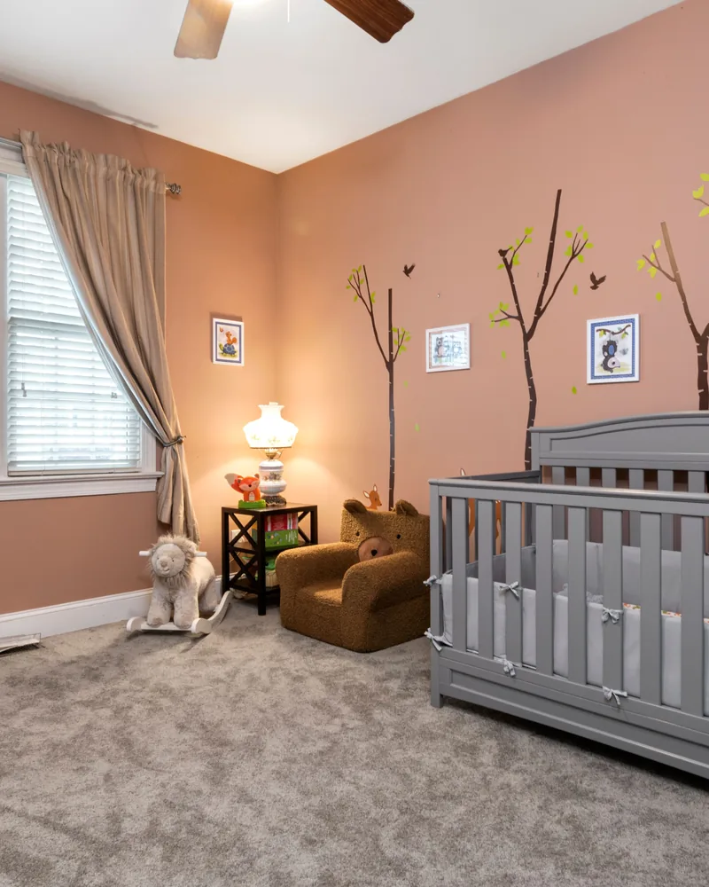 A nursery window fitted with a blind behind a curtain