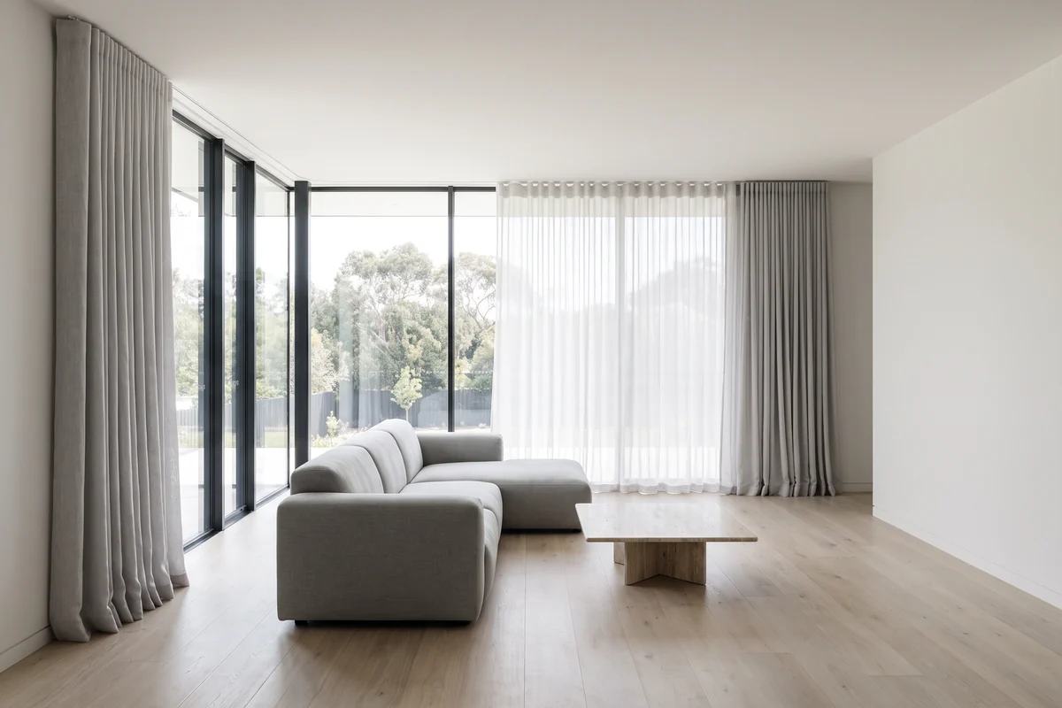 Open-plan living room with floor-to-ceiling glazing and full-height curtains