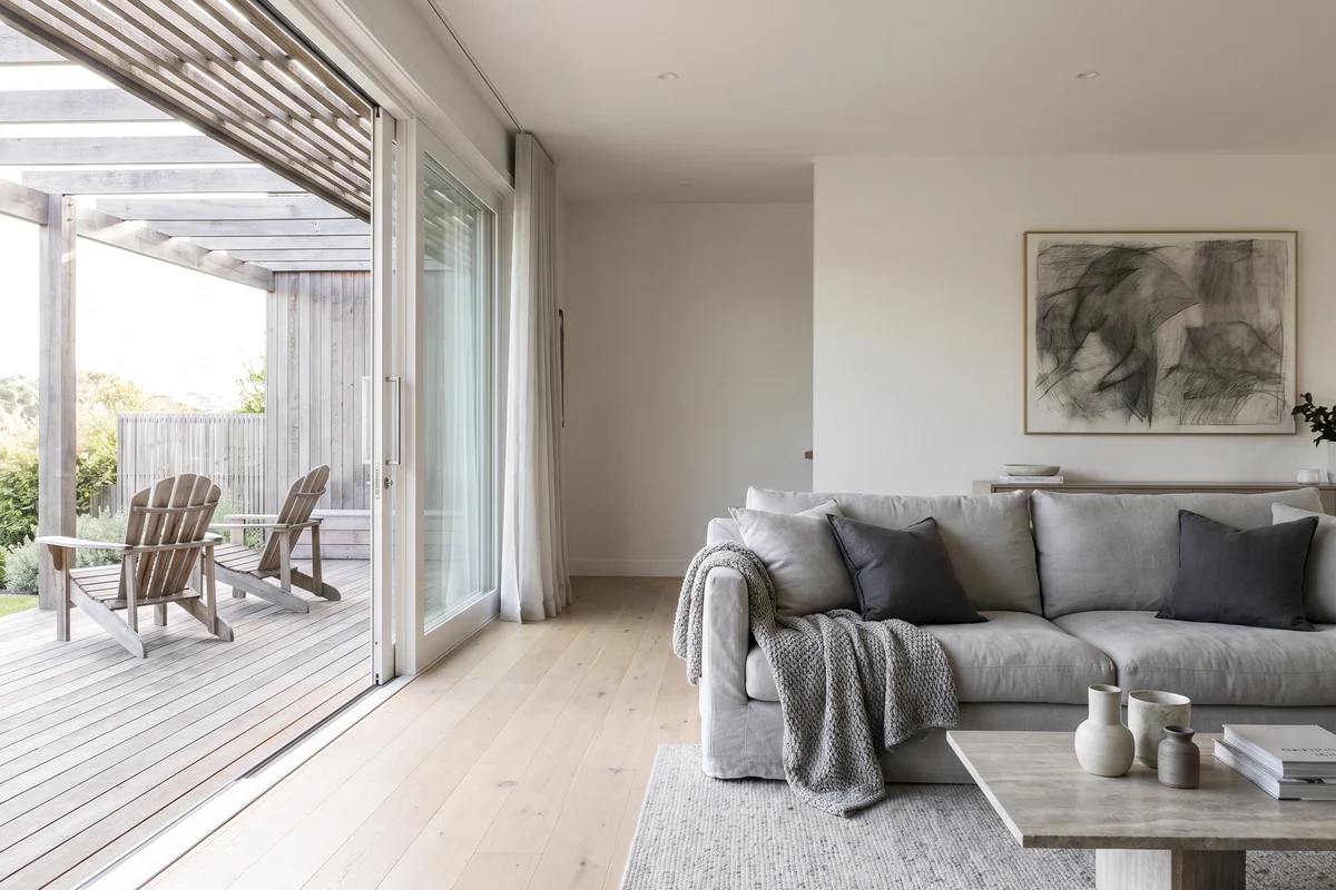 An open-plan living room opening onto a deck through a wide sliding door