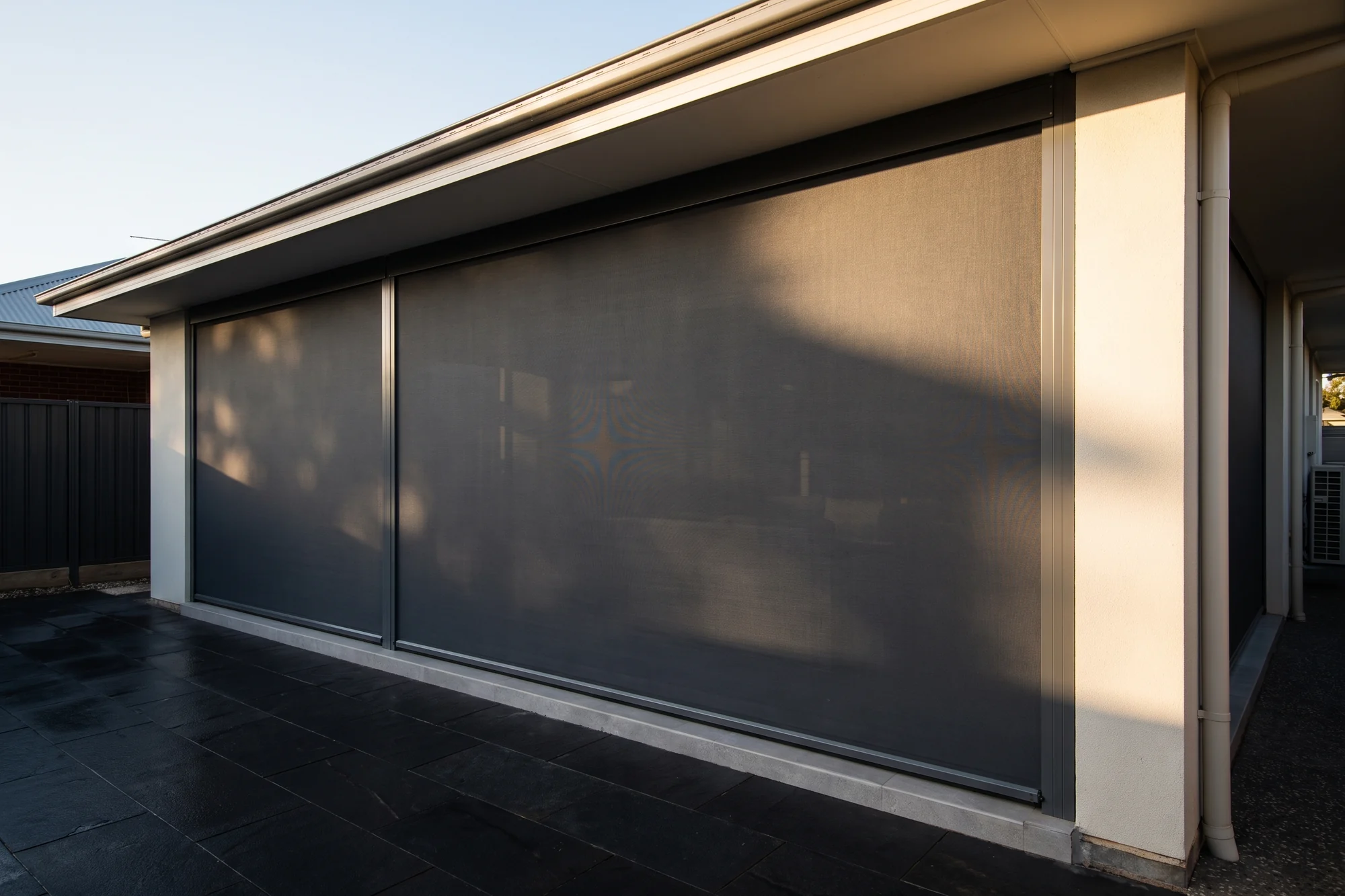 An outdoor blind lowered across an alfresco patio on a Brisbane home