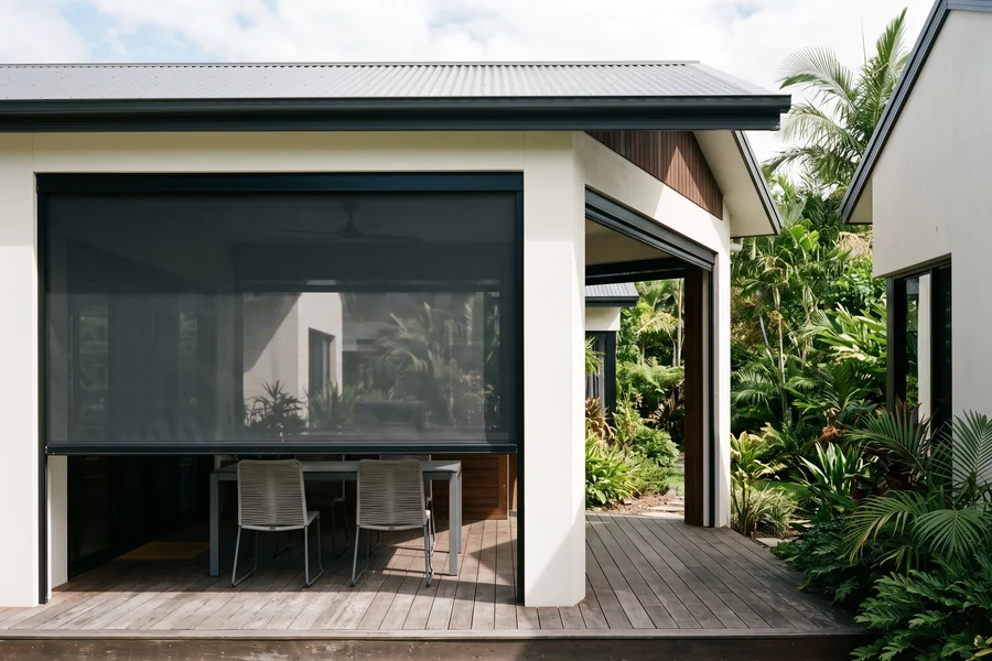 An outdoor blind lowered across one bay of an alfresco patio