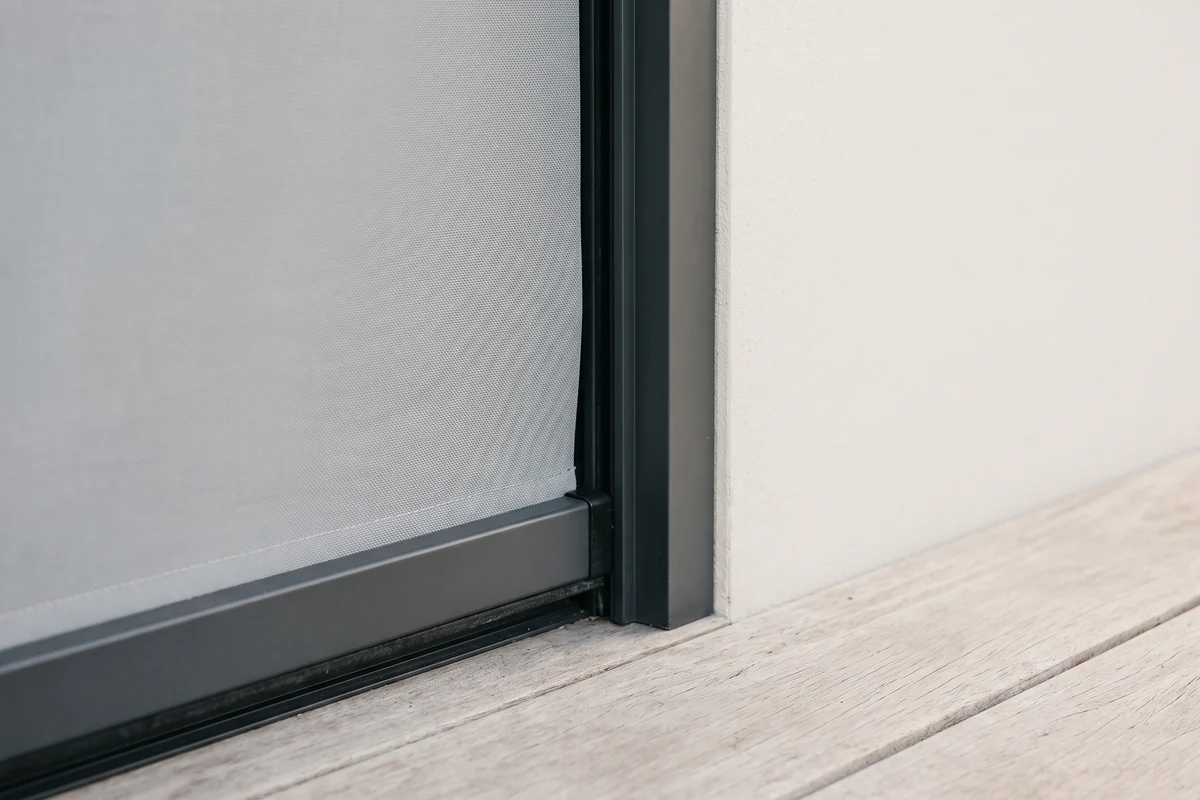 The side channel of a track-guided outdoor blind, with the fabric edge running inside it