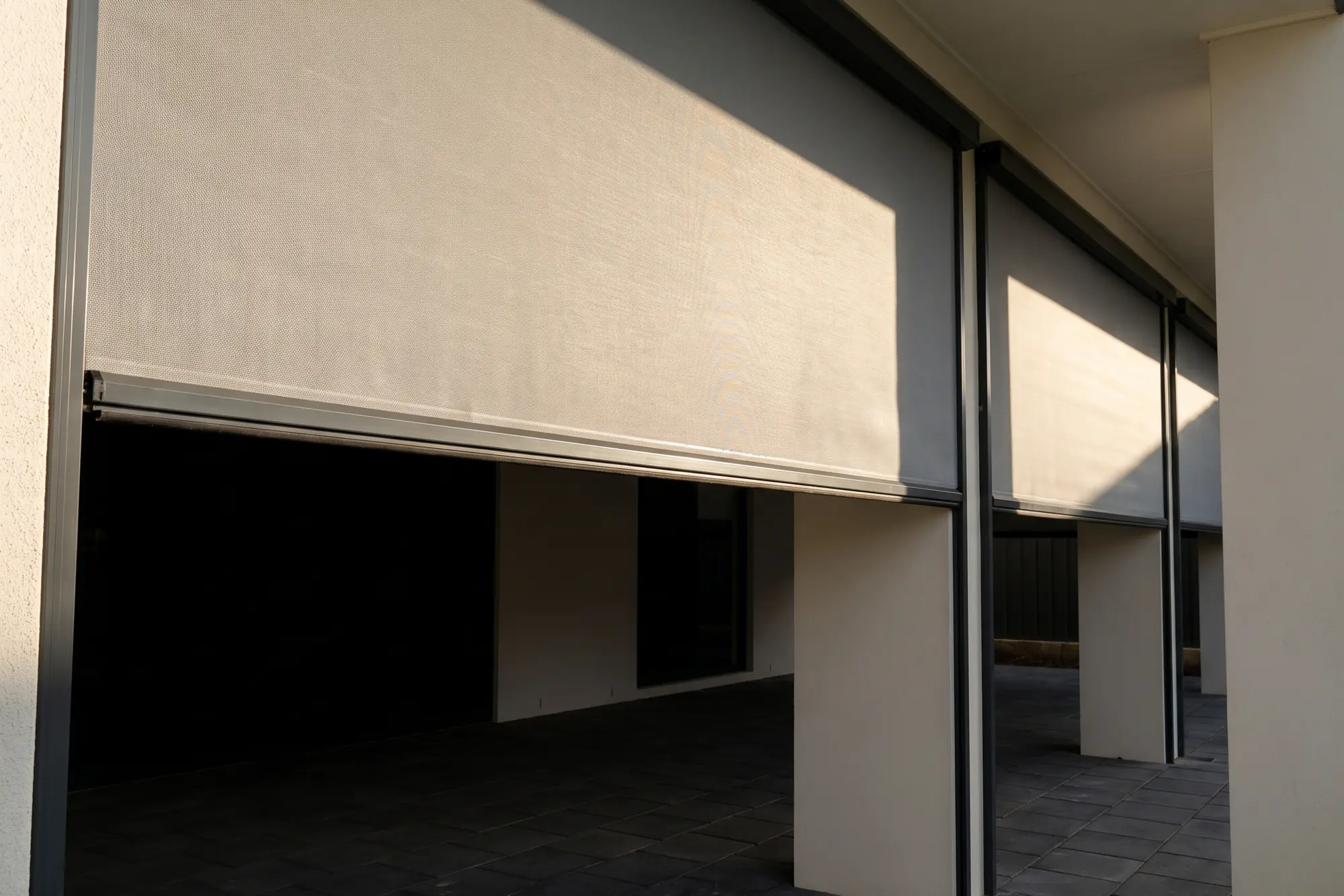 Outdoor blinds shading a covered alfresco patio and outdoor lounge setting