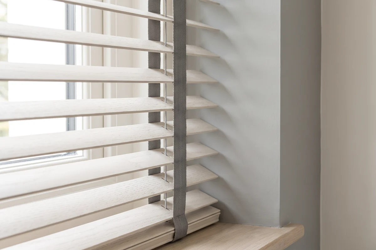 Rows of pale venetian blind slats seen close up