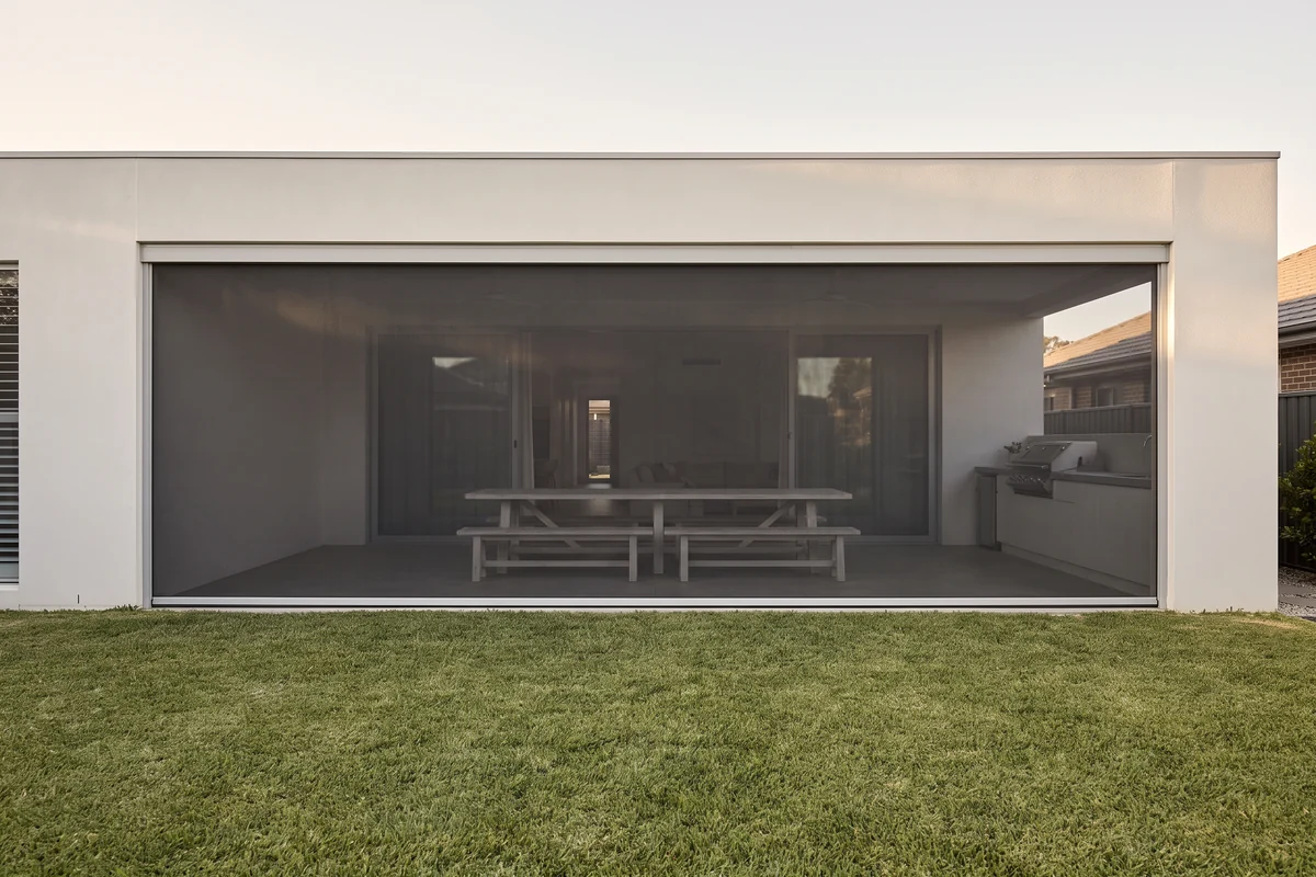 A single wide mesh screen closing a long alfresco opening with no post in the middle of the span