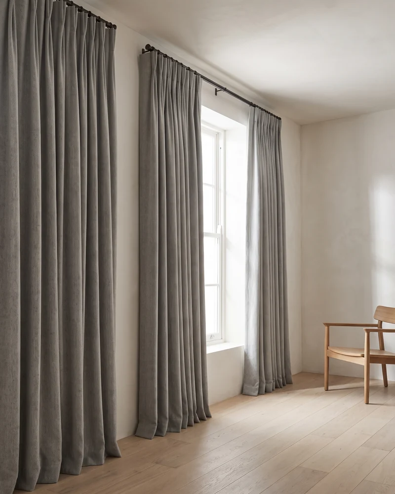 Pinch pleat blockout curtains at a window