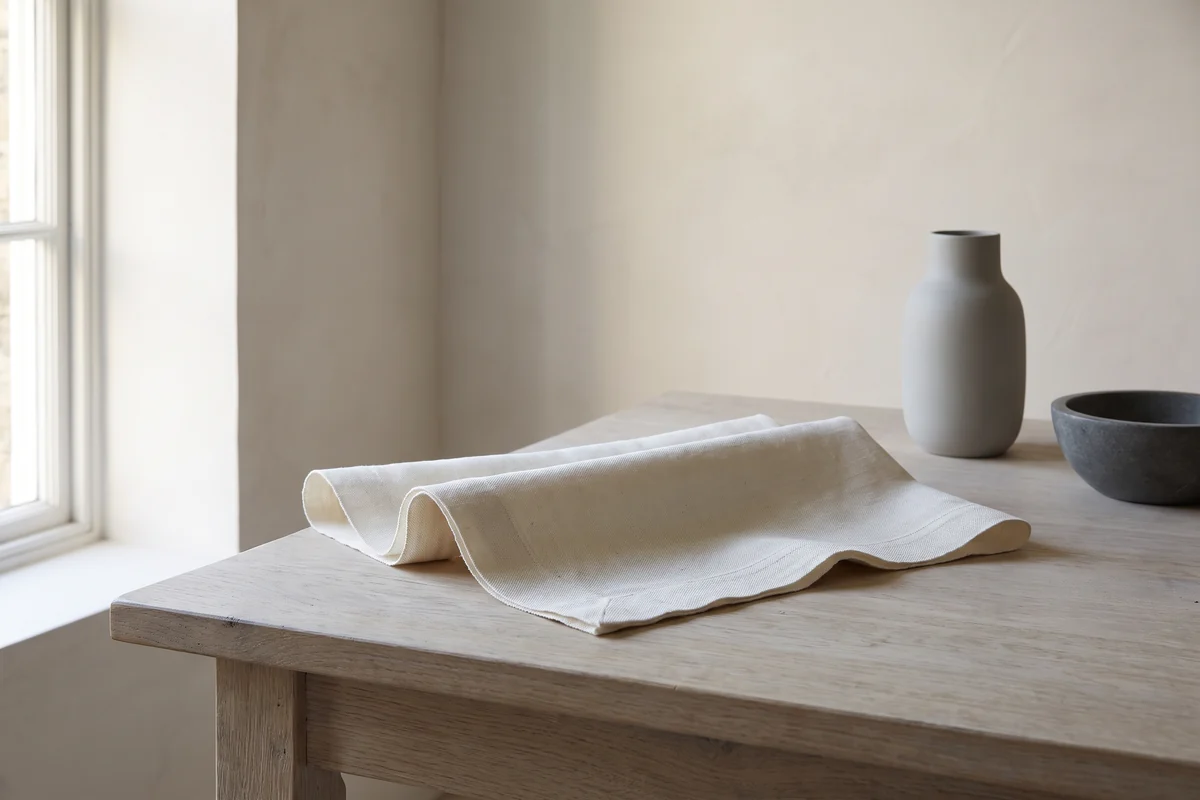 A plain woven cloth lit by natural daylight, close enough to read the weave