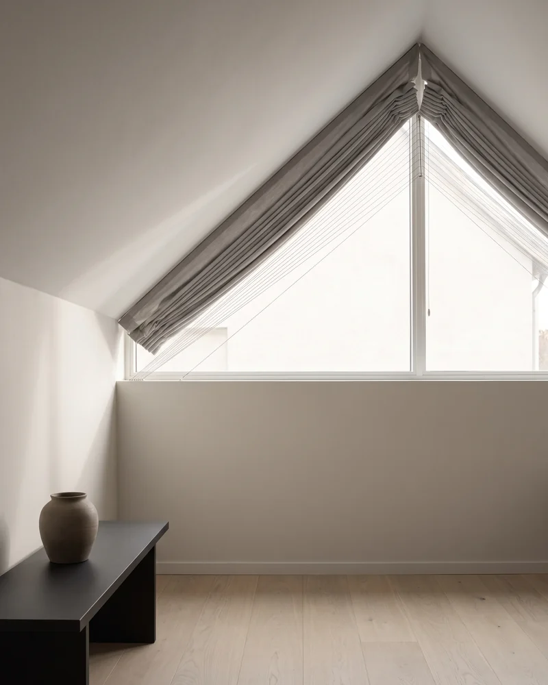 A pleated blind fitted to a gable window under a raked ceiling